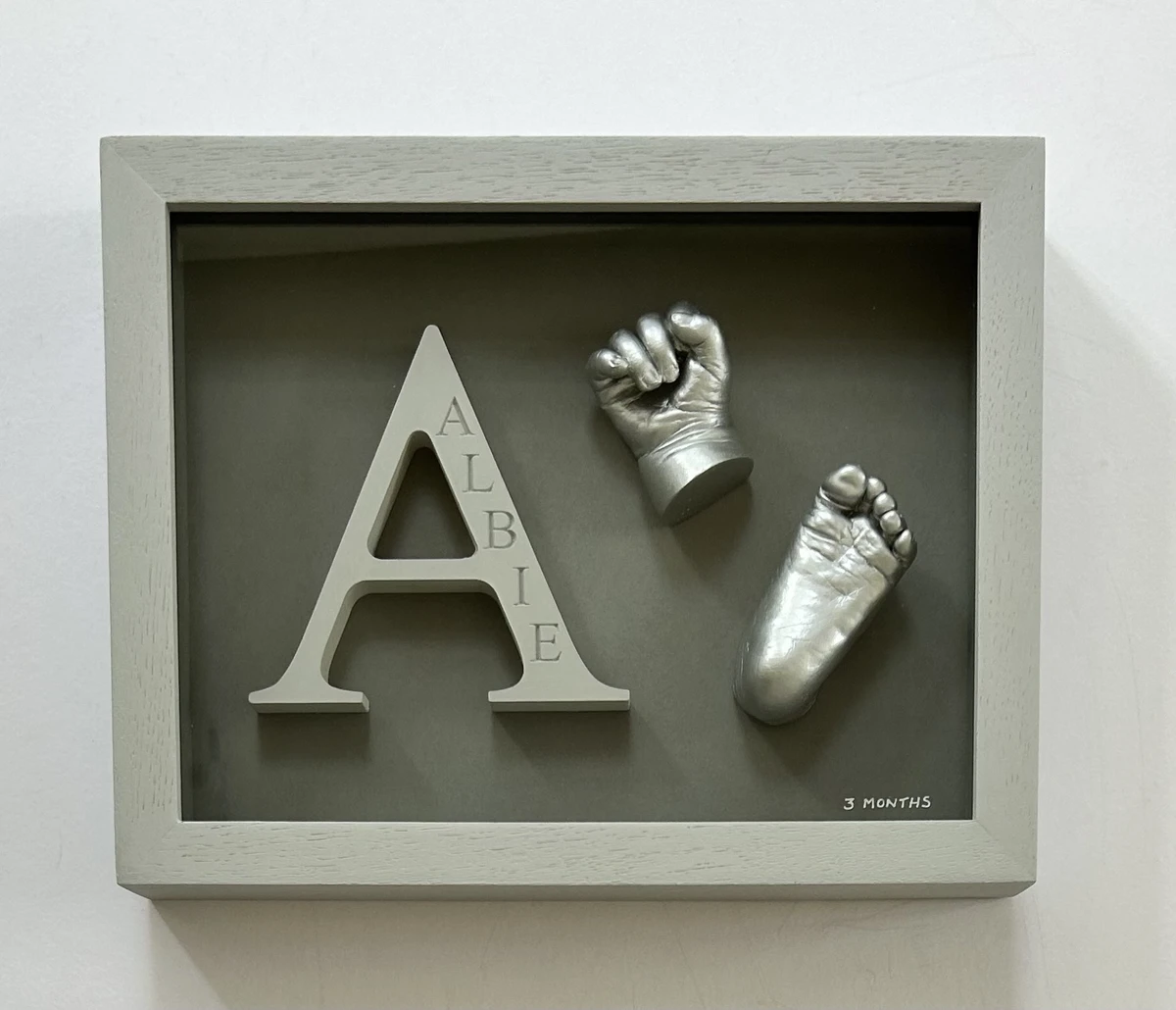 Hand and foot casts with a letter in frame